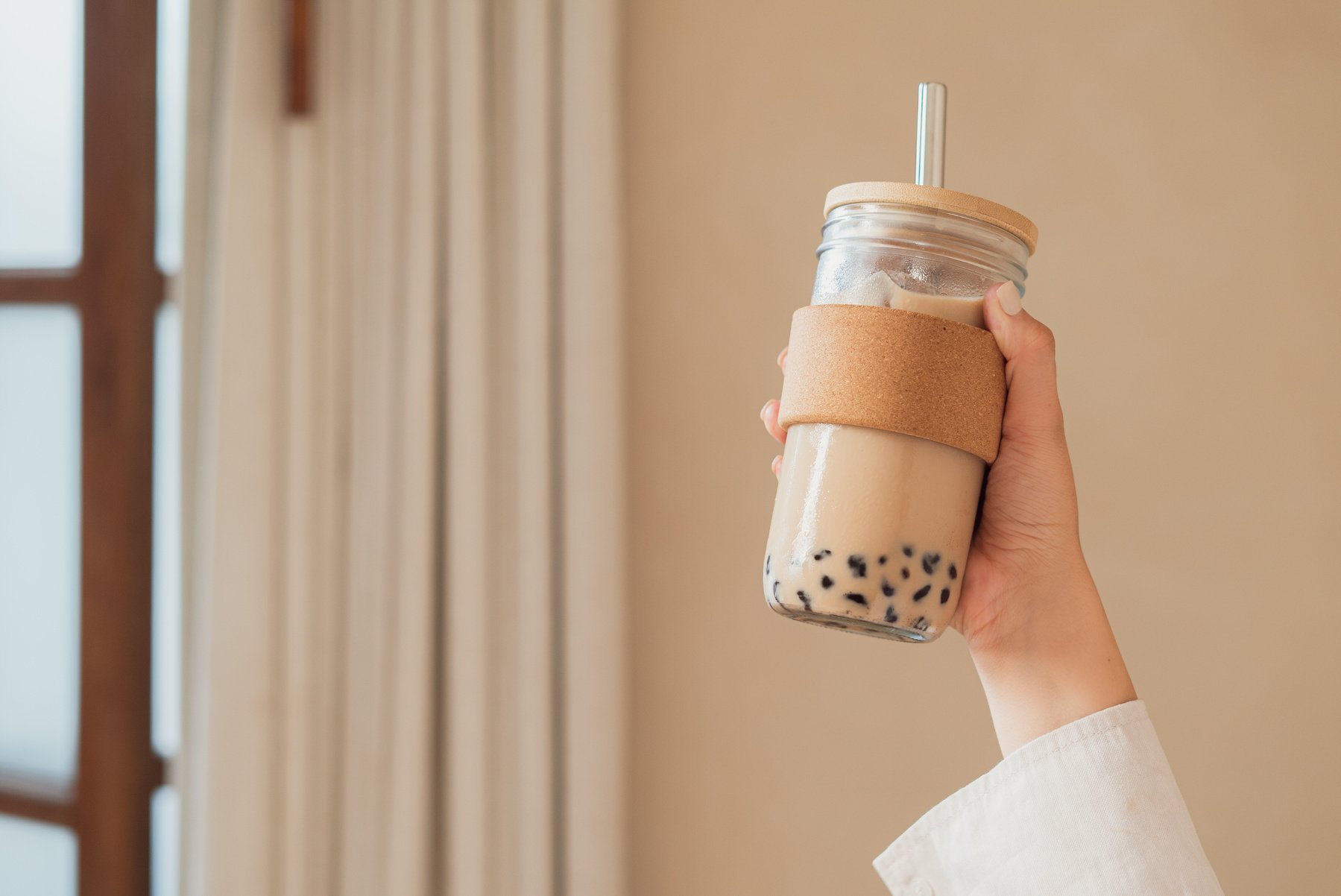 Person's Hand Holding a Glass of Pearl Milk Tea